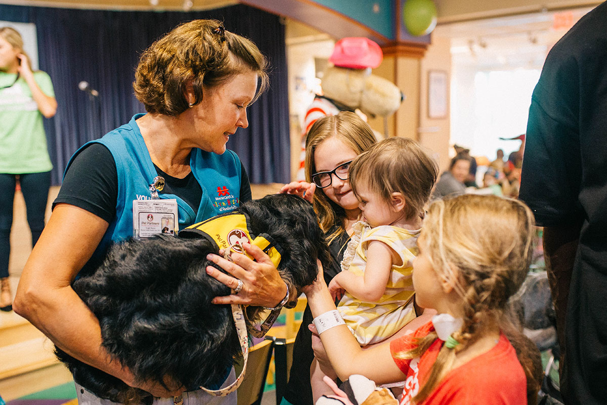 A pet team volunteer with patients at Children's Hospital